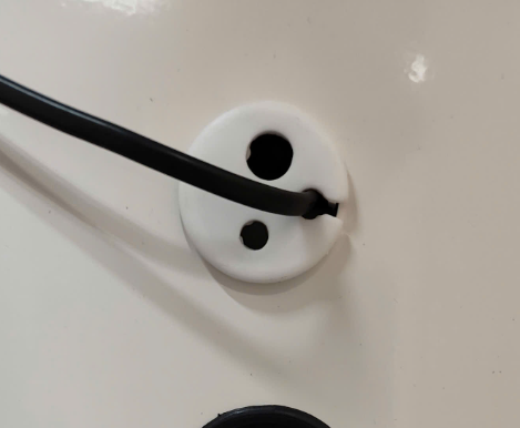 A black wire in a white outlet

Description automatically generated